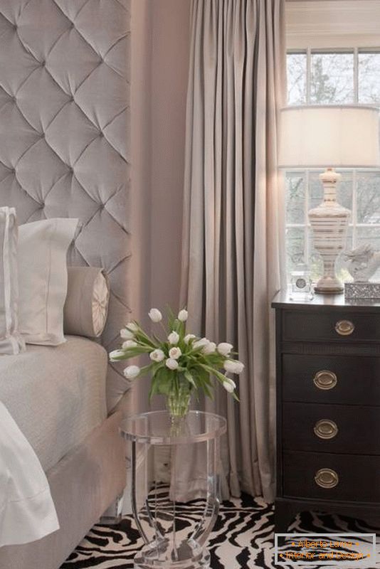 Elegante dormitorio con una alfombra inusual y una mesa transparente