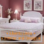 Interior de dormitorio lila con muebles blancos