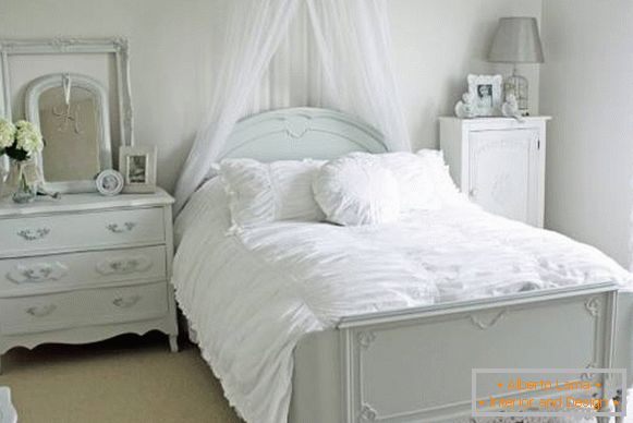 Dormitorio romántico con cama blanca y decoración