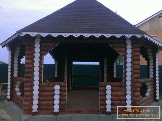 La estructura de la casa de troncos es una opción clásica para decorar el patio de una mansión de campo.