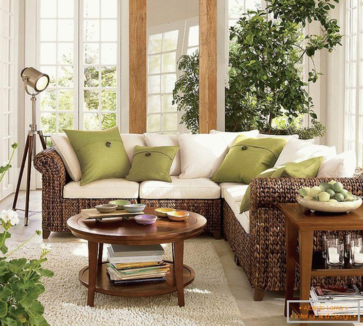 Las grandes ventanas con marcos de madera dejan entrar a la sala de estar en estilo ecológico una cantidad suficiente de luz solar, que debe prevalecer en la habitación.