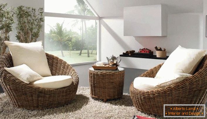 Los sillones voluminosos de mimbre con almohadas blancas y suaves con una alfombra con un montón alto serán la mejor decoración de la habitación de huéspedes en estilo ecológico.