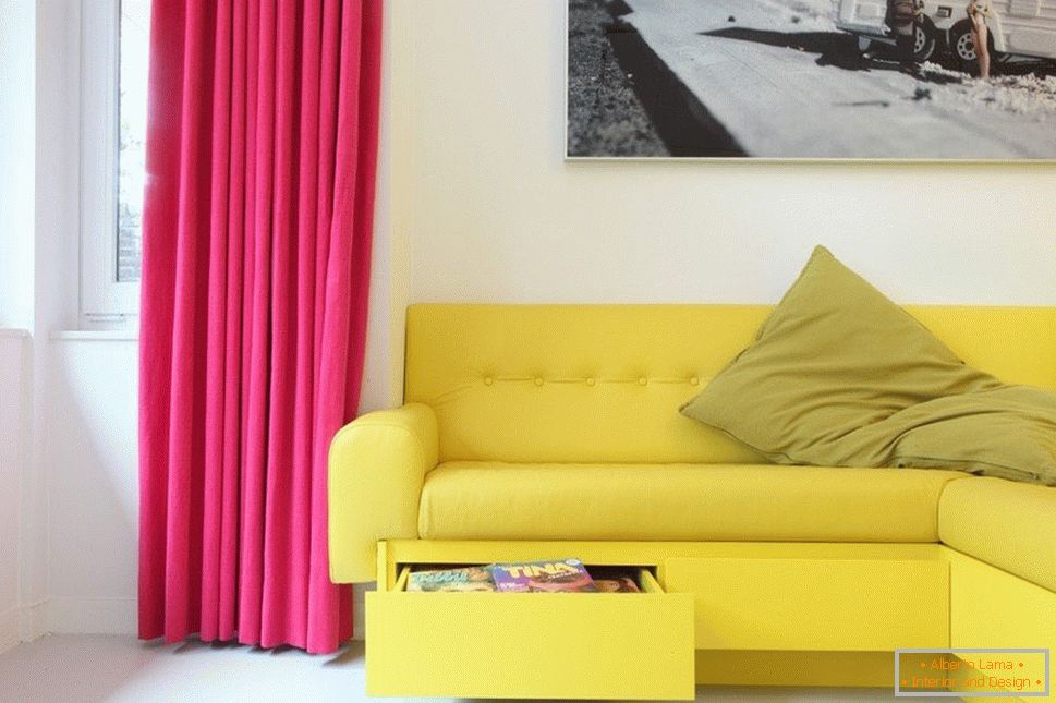 Sofá amarillo y cortinas carmesí