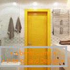 Puerta amarilla en un baño brillante