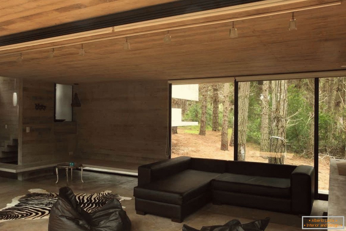 Sala de estar con acabado de madera en una casa de madera con una ventana panorámica