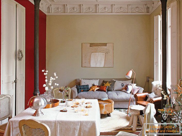 Elegante sala de estar en el estilo del eclecticismo decorado con lindas almohadas. Para la decoración de la habitación de Año Nuevo, el propietario de la casa eligió una picea interesante con adornos elegantes.