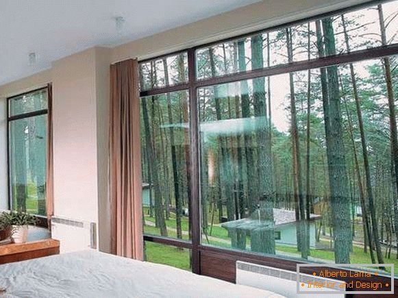 Dormitorio con grandes ventanales dentro de una casa privada