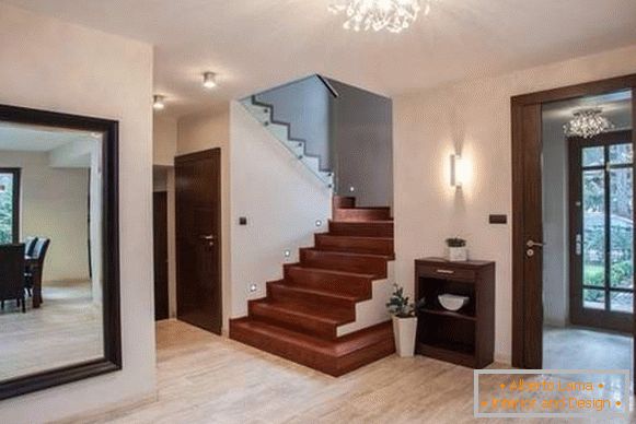 Diseño del pasillo en una casa privada con grandes espejos y escaleras