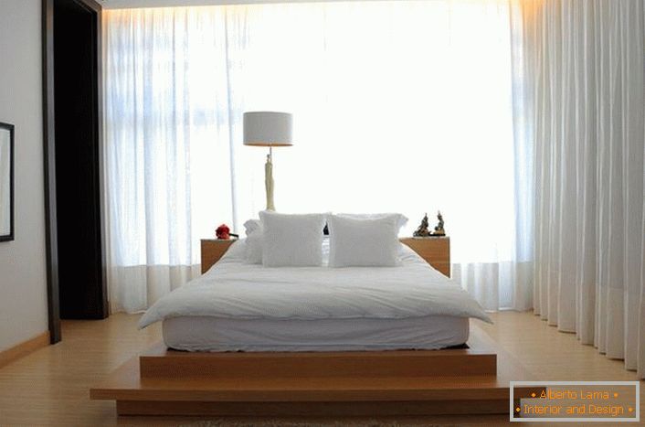 La cama se asemeja a una gran cama de plumas suaves, que se encuentra en una pasarela alta de madera. Las cortinas hechas de tela suave y translúcida hacen que el ambiente en la habitación sea romántico y relajante. 