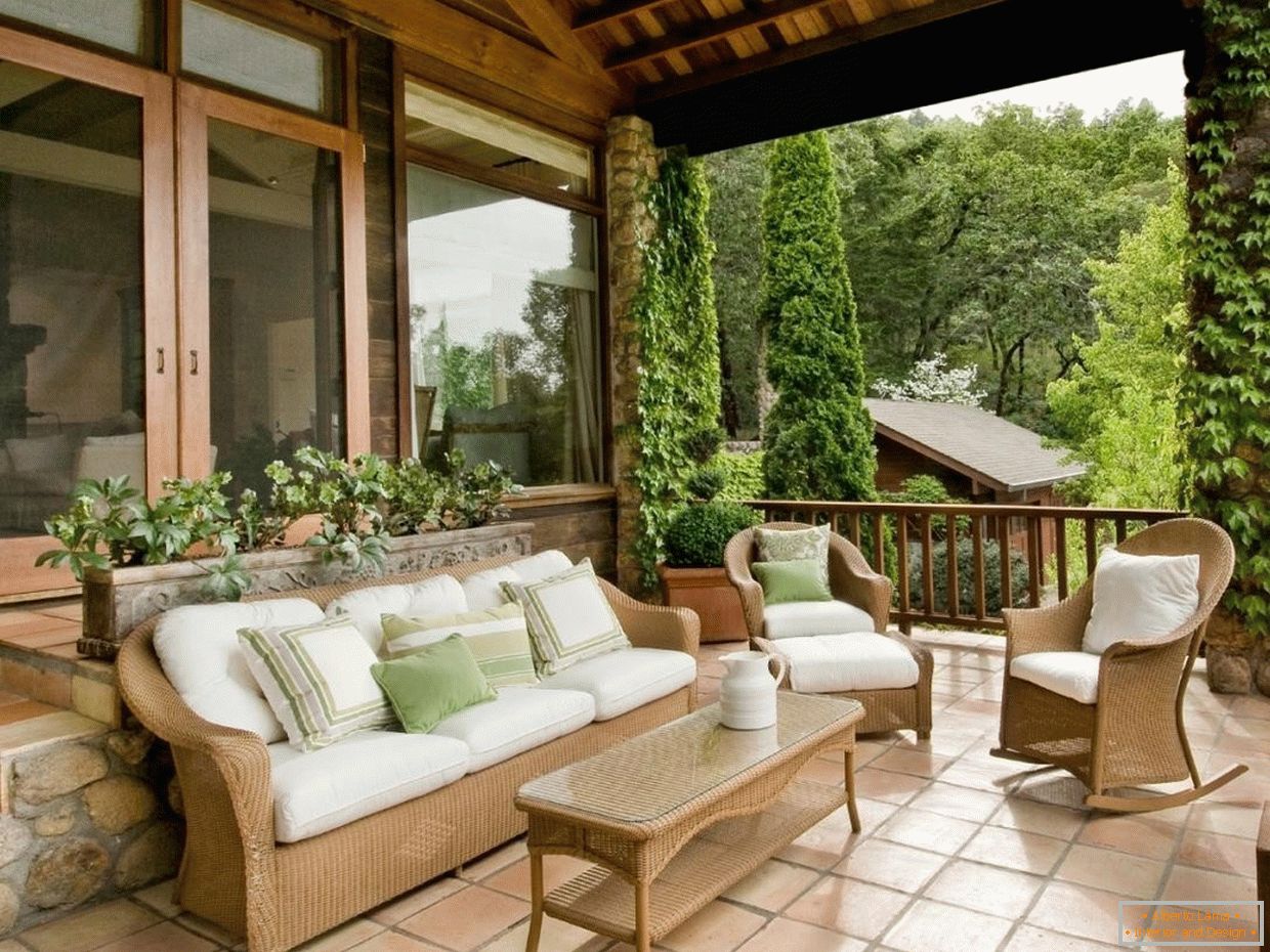 Muebles de madera con almohadas blancas en la terraza