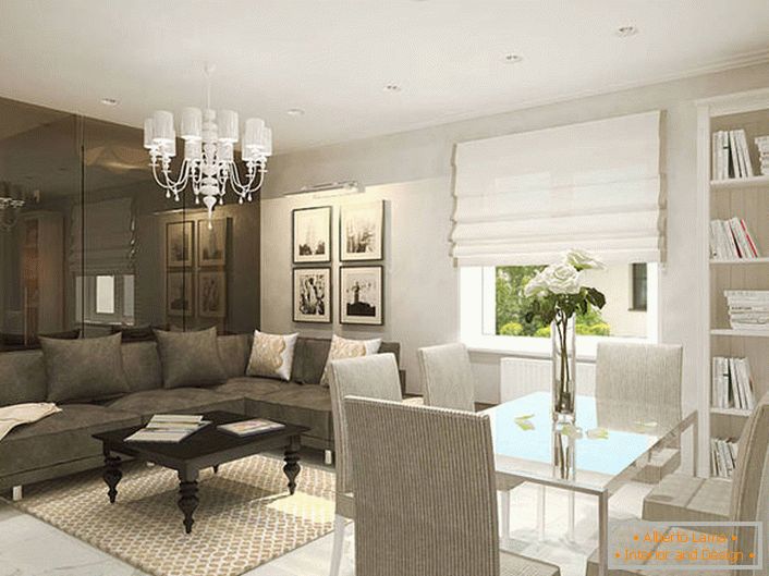 La sala de estar en un estilo moderno se divide competentemente en un área de recreación y un área de comedor con la ayuda de un juego de diseño con un esquema de color.
