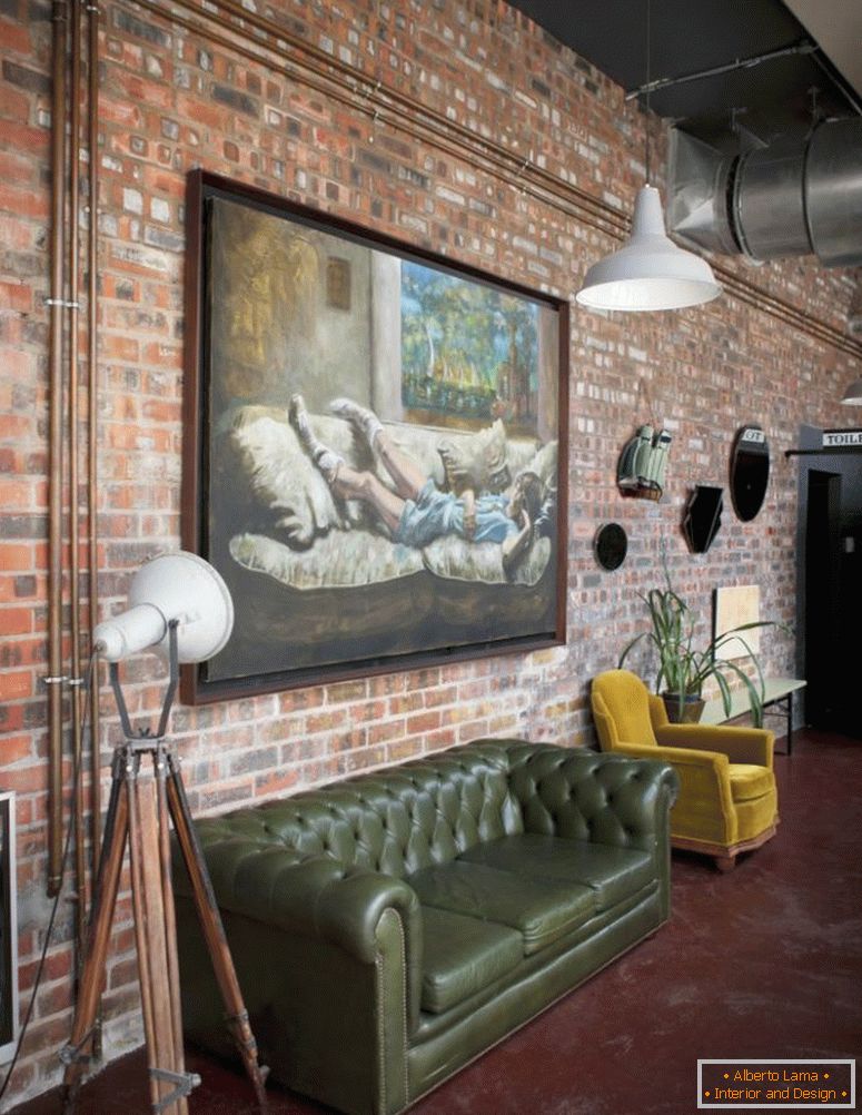 Pintura al óleo grande en la pared de ladrillo de loft de estilo industrial con sofá retro y sillón