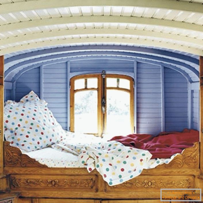 Detalles mínimos en el dormitorio en el estilo rústico. El diseñador eligió una ubicación inusual para la cama. Una cama pequeña justo en la ventana es la cama perfecta para los soñadores.