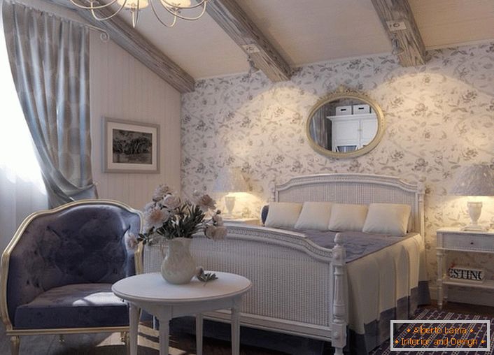 Los muebles de dormitorio en el estilo rústico se eligen armoniosamente. Son dignas de mención la lámpara de araña y las lámparas de noche con tonos clásicos.