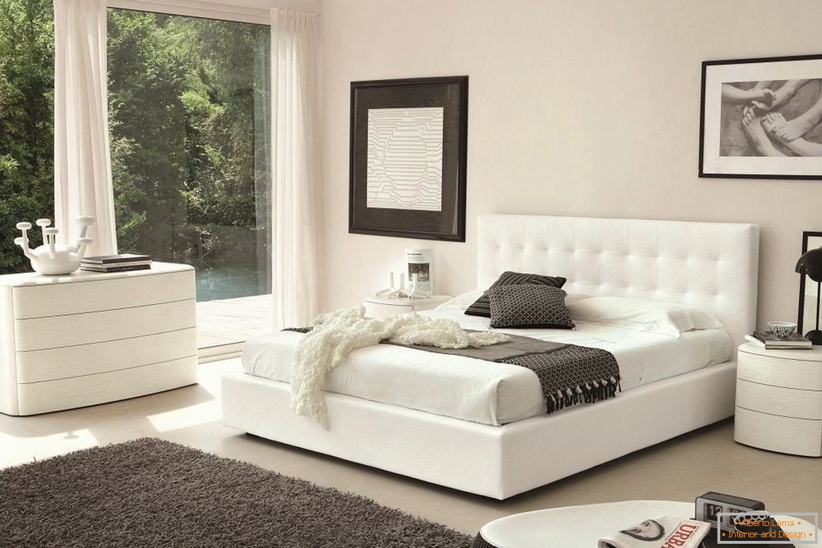 Cama blanca, cómoda y mesita de noche en el dormitorio