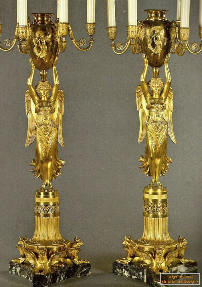 Un par de candelabros dorados idénticos decoran el dormitorio en estilo barroco. 