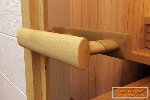 Manija de madera para puertas de vidrio en una sauna hecha de cal