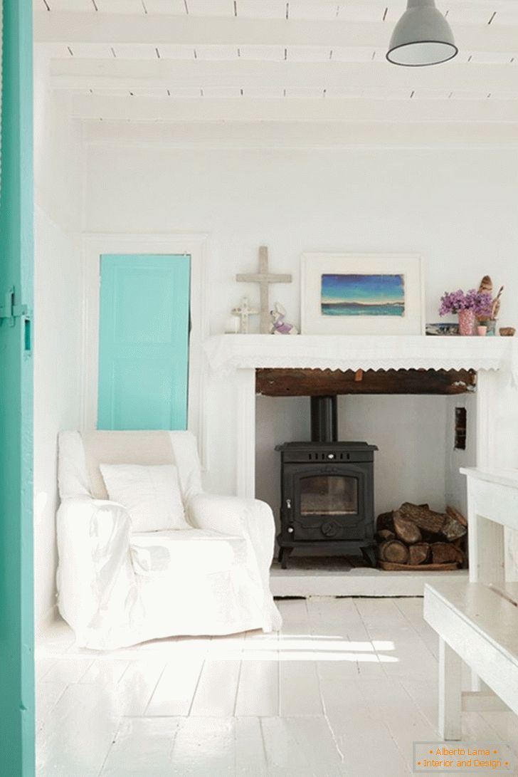 Sala de estar en tonos blancos y turquesas con chimenea
