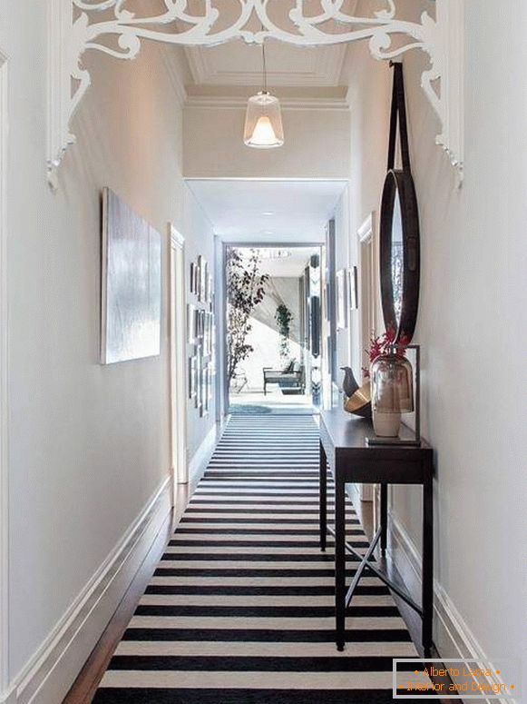 Diseño de un estrecho pasillo largo en un apartamento con una alfombra