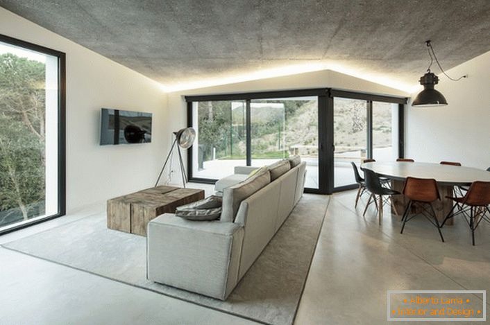 Estilo moderno moderno en su mejor manifestación. Los colores gris claro y blanco resuenan armónicamente entre ellos. Una solución de color clásico para decorar una amplia sala de estar.