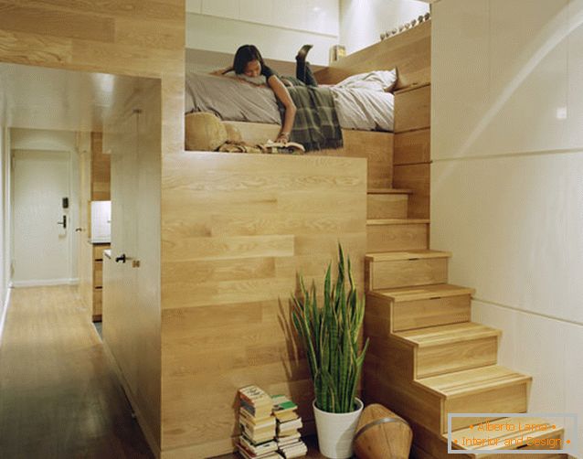 Cama de dos niveles en un departamento rectangular con una ventana