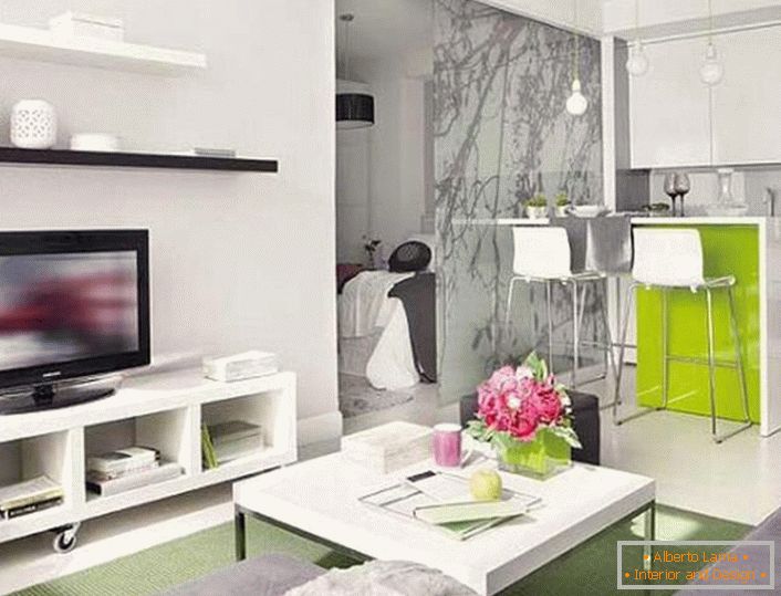 Un pequeño apartamento estudio gracias a un diseño competente se convierte en una vivienda de pleno derecho con un dormitorio separado, que está vallado por una elegante mampara de cristal.