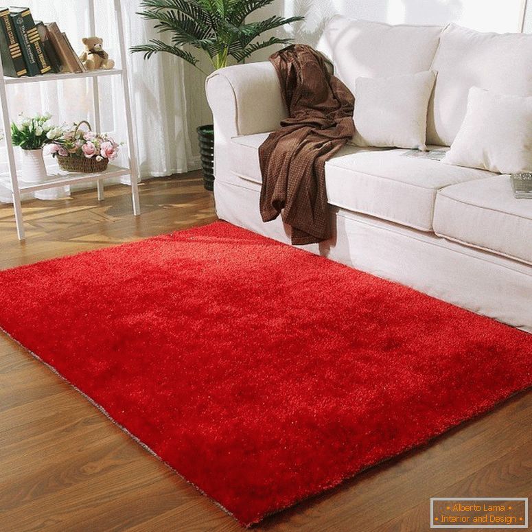 Alfombra roja frente a un sofá blanco