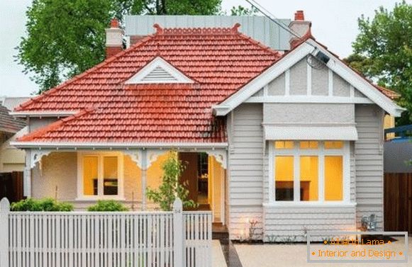 La fachada moderna de una casa privada es blanca con techo rojo