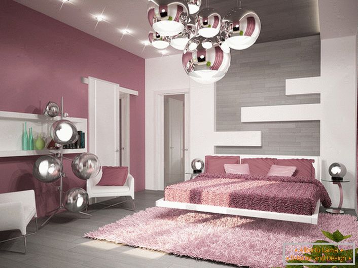 Un ejemplo de iluminación bien elegida para un dormitorio en el estilo de alta tecnología. La araña del techo, las lámparas de noche y la lámpara de pie están hechas con el mismo estilo.