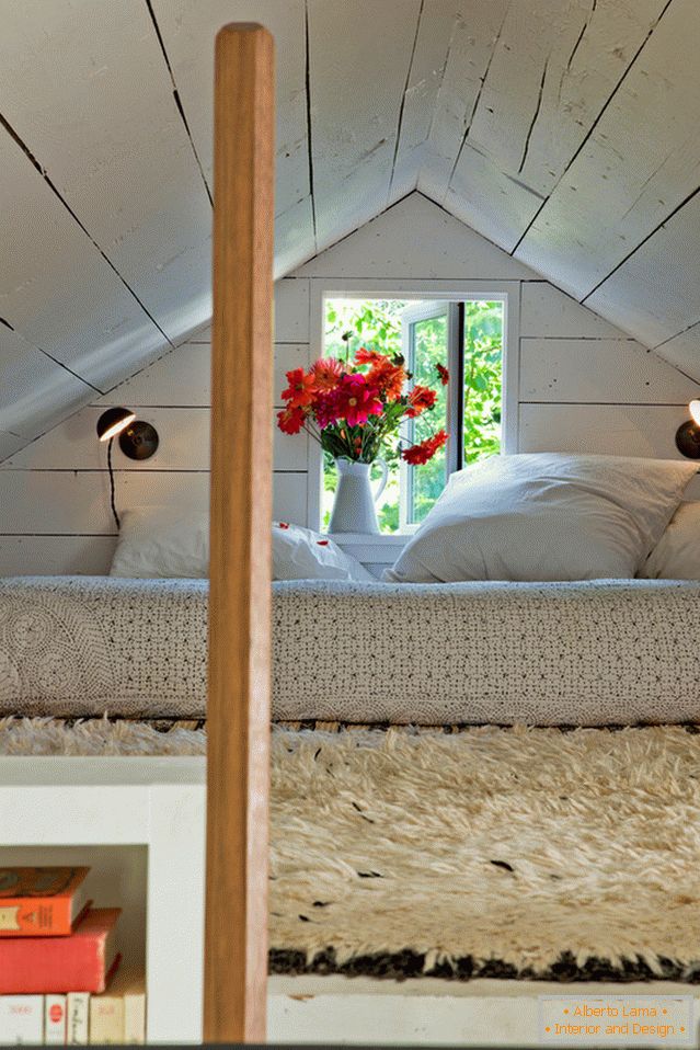 Dormitorio bajo el techo en una pequeña casa acogedora