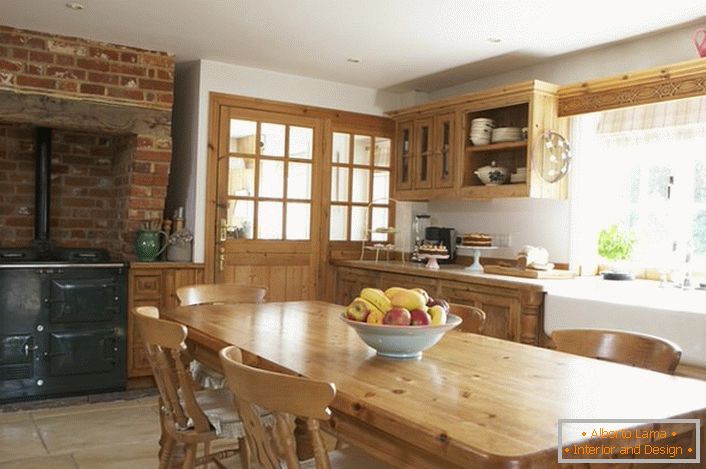 Amplia cocina en estilo rústico. Los muebles de madera y la decoración de ladrillo sobre la estufa le dan un estilo natural y romántico.