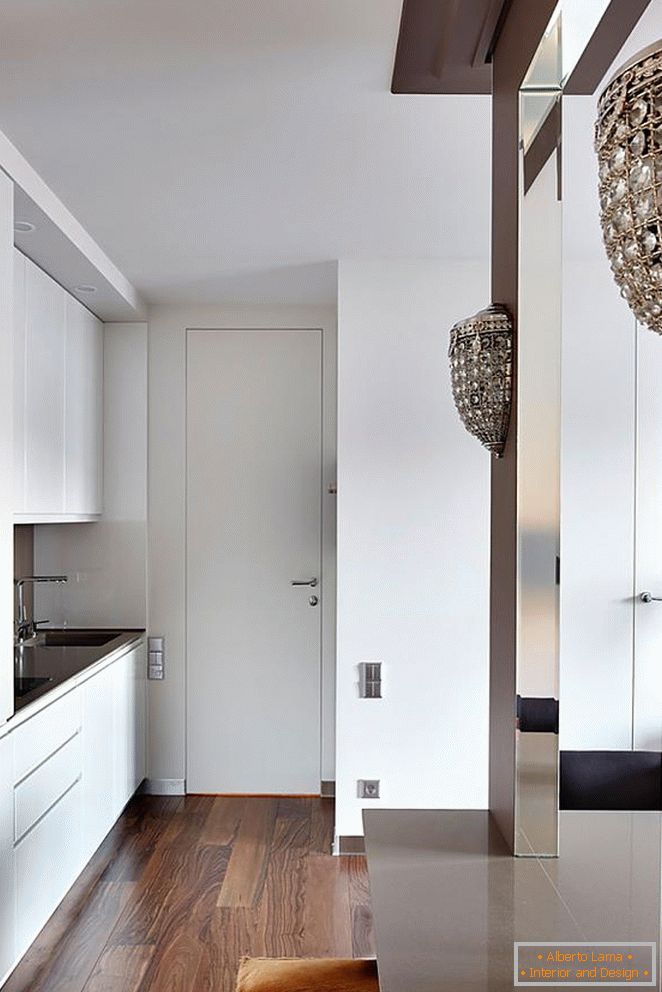 Muebles de cocina blancos, puerta de entrada blanca y hermoso parquet de madera