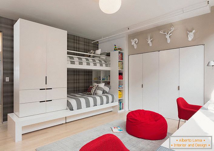 Una gran sala para niños en estilo de alta tecnología para gemelos. La atención atrae a los muebles rojos y el armario, montados en la pared.