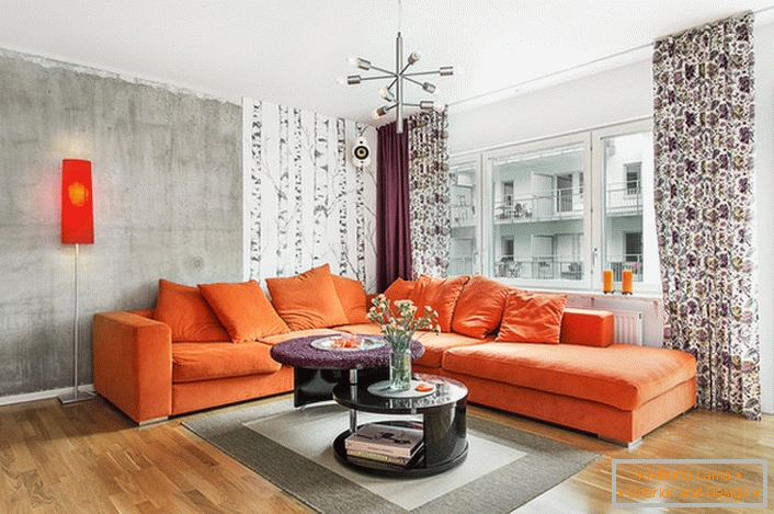 El estilo escandinavo es inherente al uso de colores cálidos en el diseño interior. El sofá naranja suave mira orgánicamente el fondo de las paredes de un tono gris frío.