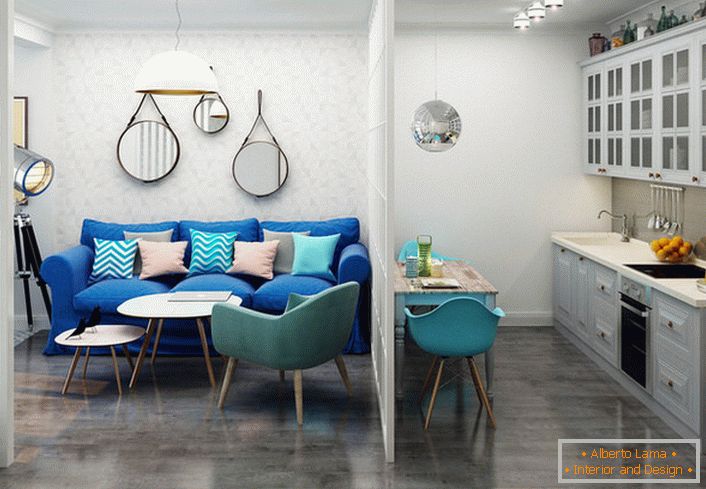 El sofá azul oscuro contrasta con el acabado claro. Un ejemplo de diseño exitoso de un apartamento pequeño de una habitación.