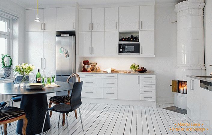 Chimenea de azulejos, hecha con baldosas de cerámica blanca, encaja orgánicamente en el interior de la cocina en estilo escandinavo.