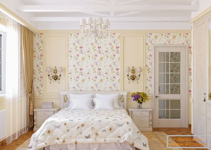 Las paredes del dormitorio en el estilo rural están decoradas con papel tapiz de flores, que se mezclan armoniosamente con la colcha en la cama.