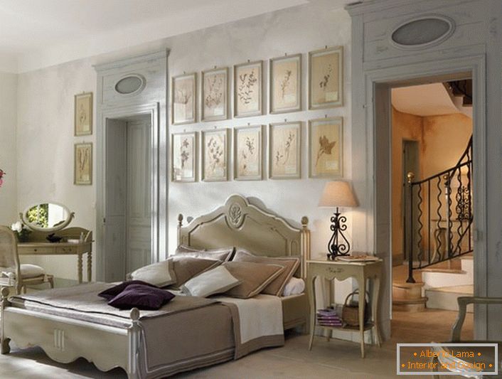 De acuerdo con las tradiciones del estilo francés para el dormitorio fue seleccionado muebles de madera lacónicos ligeros. Un detalle interesante es un collage de imágenes sobre la cabecera de la cama.