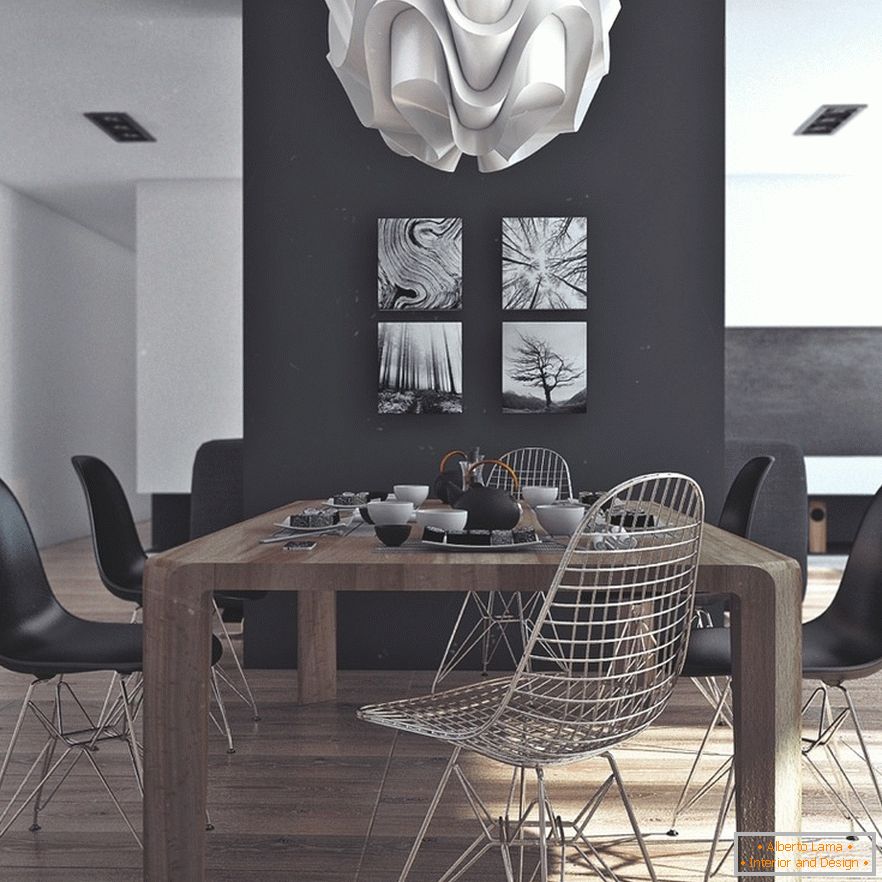 Una mesa de comedor de madera, sillas negras y pinturas originales en una pared negra