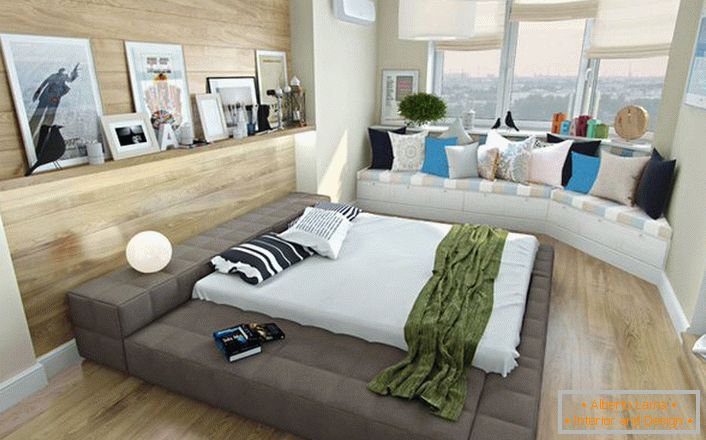 Una solución interesante para un dormitorio de estilo escandinavo es un pequeño sofá debajo de la ventana, decorado con almohadas brillantes. 