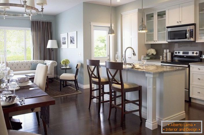 Elegido en el estilo de la zona de recreo, los muebles de cocina no estropean el estado de ánimo general de una amplia sala de estar.