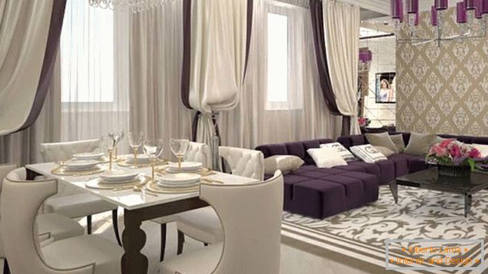 Las pesadas cortinas de las ventanas en combinación con los suaves muebles de color blanco y lila se combinan para recrear el interior en el estilo del art deco. De acuerdo con el estilo, la iluminación también se selecciona. La araña del techo está decorada con los mismos tonos brillantes de color púrpura oscuro.