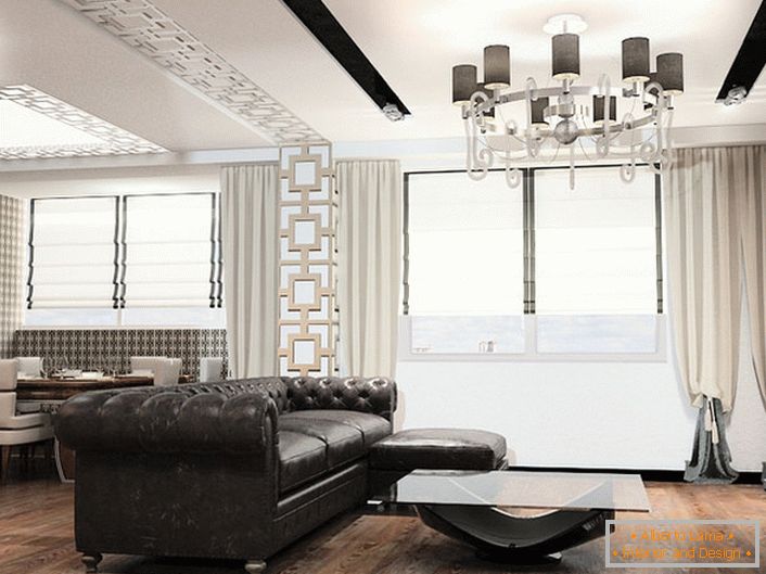 El mobiliario en el estilo del art deco siempre es de gran tamaño. Ideal para decorar la sala de estar en este concepto estilístico es un sofá de cuero con tapizado acolchado.