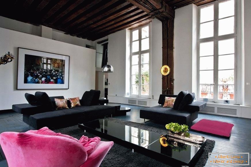 Sofás negros y un sillón rosa en la habitación