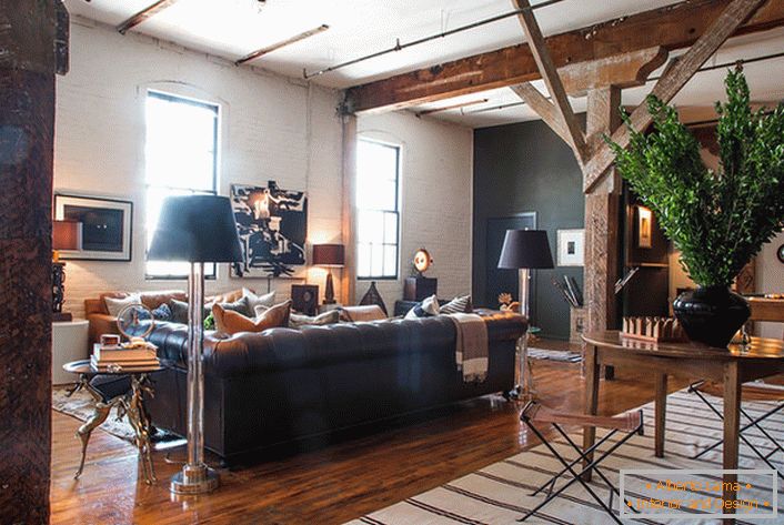 Una atmósfera creativa reina en la sala de estar en un estilo loft. Los detalles brillantes hacen que la habitación sea acogedora y cálida.
