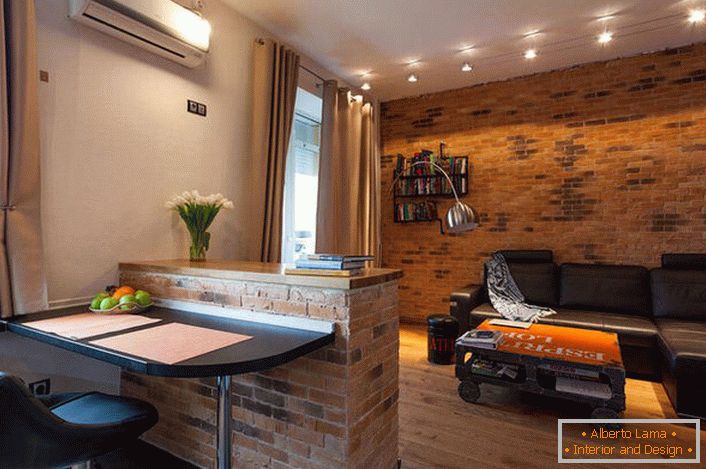 La pared de la sala de estar está decorada de acuerdo con el estilo loft. La albañilería es uno de los elementos más populares.