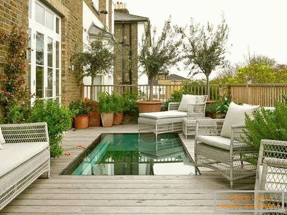 Terraza al aire libre junto a la casa con una piscina - foto