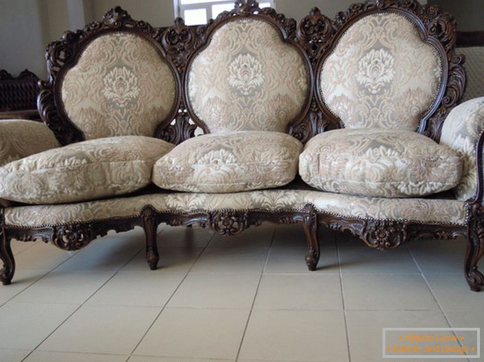 Ribete adornado de la parte posterior, patas talladas, tapicería textil: la opción perfecta para una sala de estar de estilo barroco.