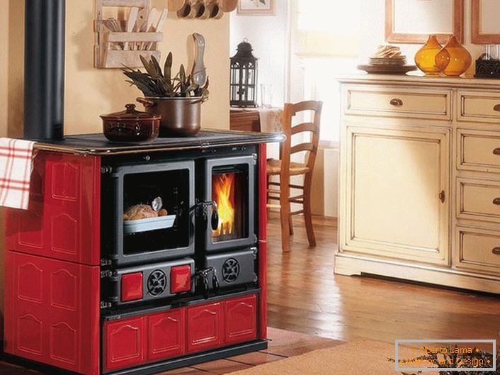 La chimenea en colores rojo y negro es una decoración de la cocina en el estilo de la Provenza.