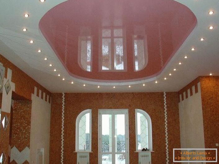Techo ovalado de color rosa con iluminación LED en una habitación grande en una casa de campo.